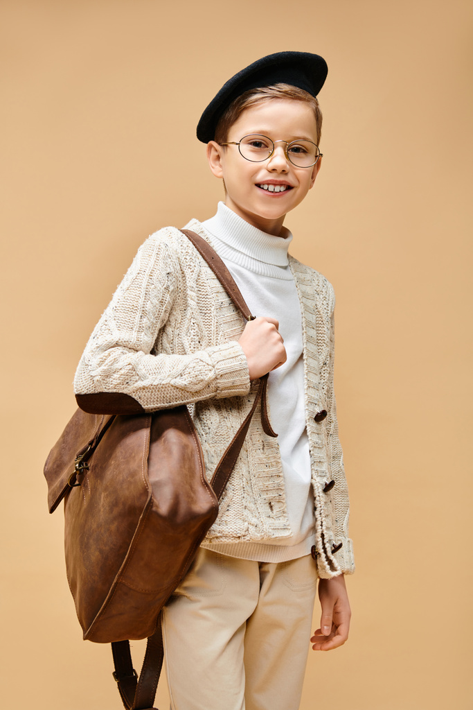 Ένα χαριτωμένο προεφηβικό αγόρι ντυμένο σαν σκηνοθέτης, με γυαλιά και καπέλο.. - Φωτογραφία, εικόνα