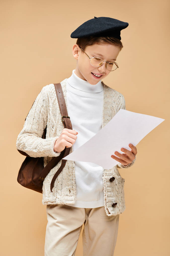 Niño en gafas y sombrero, sosteniendo papel, vestido como director de cine. - Foto, Imagen