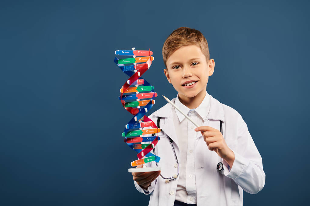 A cute preadolescent boy, dressed as a doctor, holds a model of a structure with curiosity. - Photo, Image