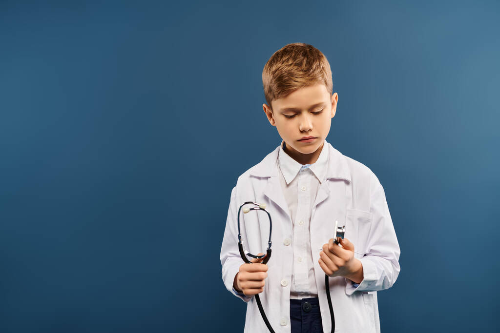 Ein kleiner Junge als Arzt verkleidet, mit Stethoskop in der Hand. - Foto, Bild