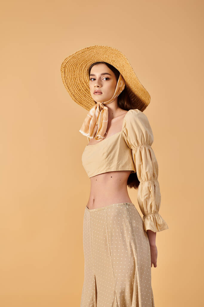 Молодая женщина с длинными брюнетками излучает летние вибрации в соломенной шляпе и платье, источая элегантность и изящество. - Фото, изображение