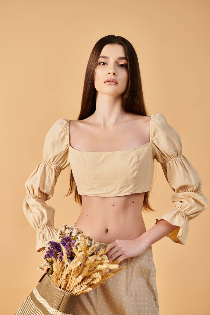 流れるスカートのブルネットの女性は喜んで花の活気に満ちた花束を保持し,夏の本質を体現しています. - 写真・画像