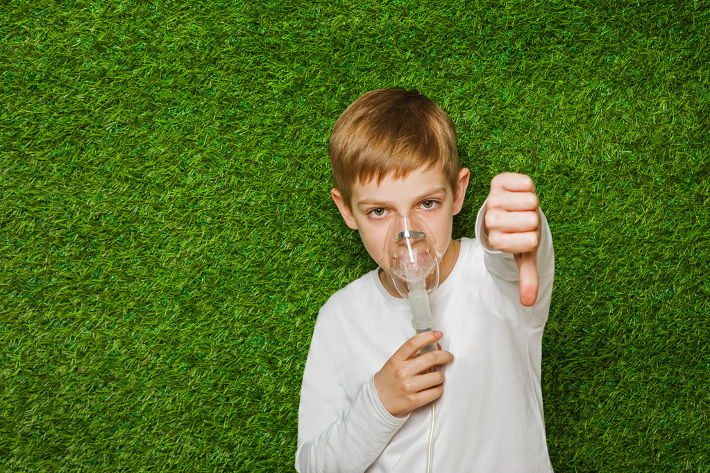Chłopiec oddychanie przez inhalator maska kciuk w dół - Zdjęcie, obraz