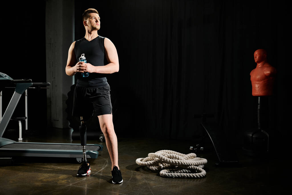 Un homme avec une prothèse de jambe se tient avec confiance devant l'équipement de gymnastique, montrant détermination et résilience dans sa routine d'entraînement. - Photo, image