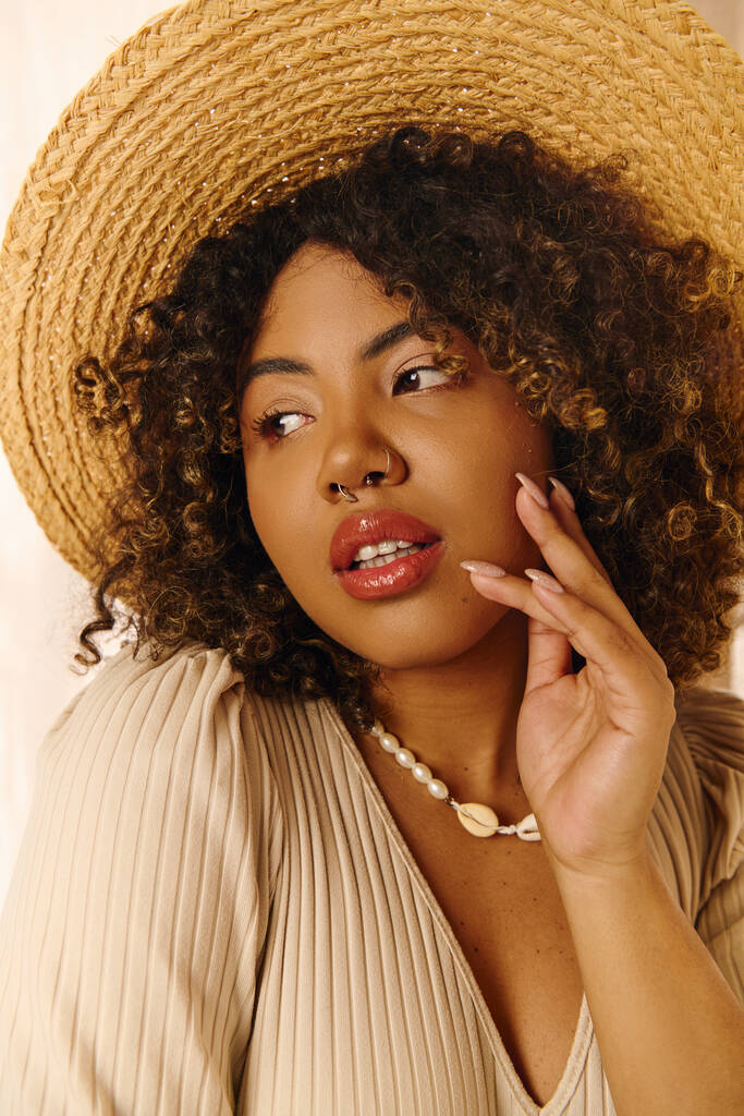 Eine schöne junge Afroamerikanerin mit lockigem Haar und Sommerkleid posiert in einem Studio für ein Foto. - Foto, Bild