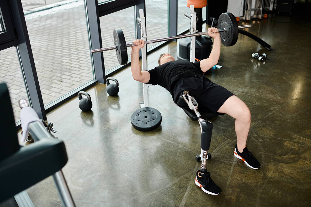Un uomo con una gamba protesica esegue un potente stacco in palestra, mostrando determinazione e forza. - Foto, immagini