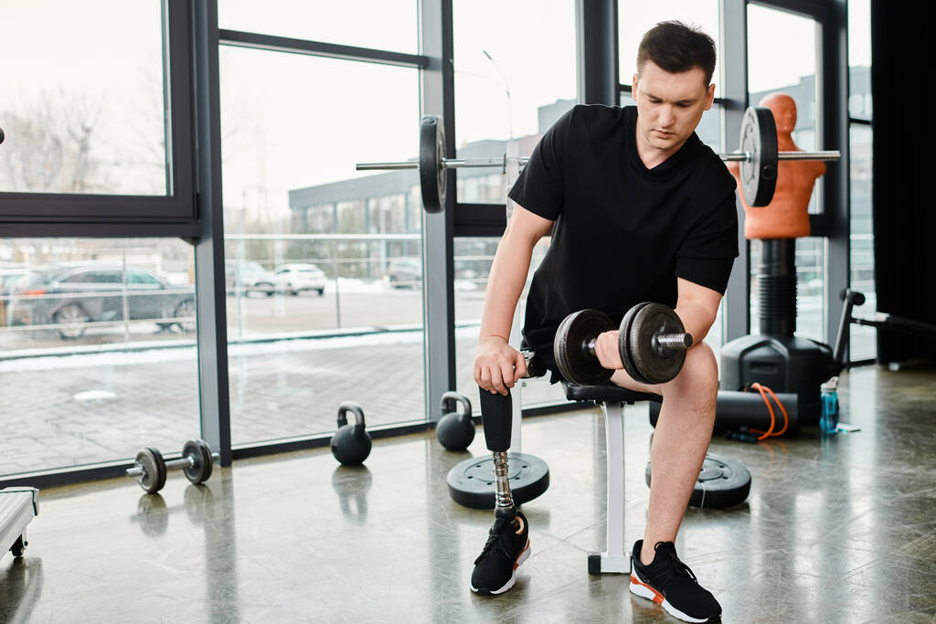 Ένας αποφασισμένος άνθρωπος με προσθετικό πόδι γυμνάζεται με ένα κουδούνι σε ένα γυμναστήριο, αγωνιζόμενος για δύναμη και ενδυνάμωση. - Φωτογραφία, εικόνα