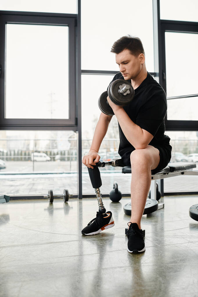 Ein Mann mit Beinprothese sitzt auf einer Bank und hält eine Kettlebell in der Hand und konzentriert sich auf sein Workout im Fitnessstudio. - Foto, Bild