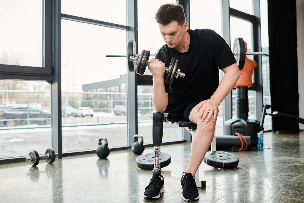 Визначений чоловік з протезною ногою виконує присідання, тримаючи гантелі в спортзалі. - Фото, зображення
