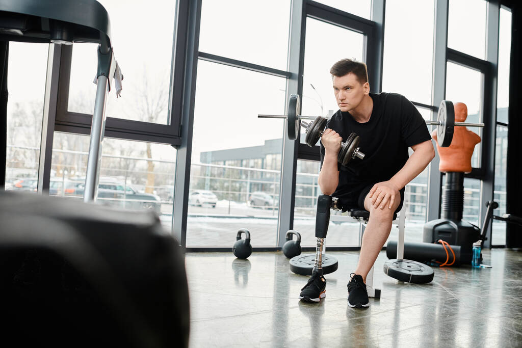 A determined disabled man with a prosthetic leg is squatting on a bench in the gym during a workout session. - Photo, Image
