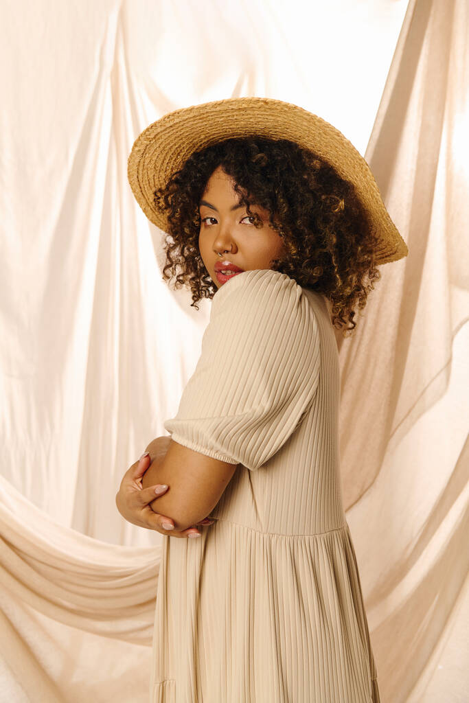 Красива молода афроамериканка з кучерявим волоссям у капелюсі та літній сукні в студійній обстановці. - Фото, зображення