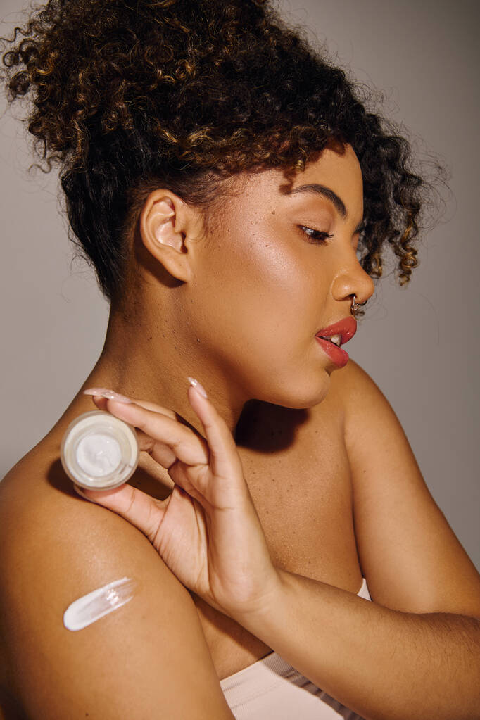 Uma bela jovem afro-americana com cabelo encaracolado coberto por uma espessa camada de creme, enfatizando beleza e cuidados com a pele. - Foto, Imagem