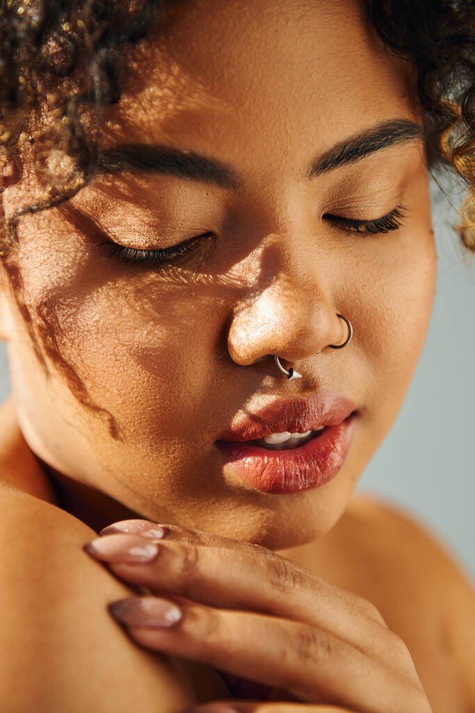 Close-up van een Afro-Amerikaanse vrouw met gesloten ogen die rust uitstraalt. - Foto, afbeelding