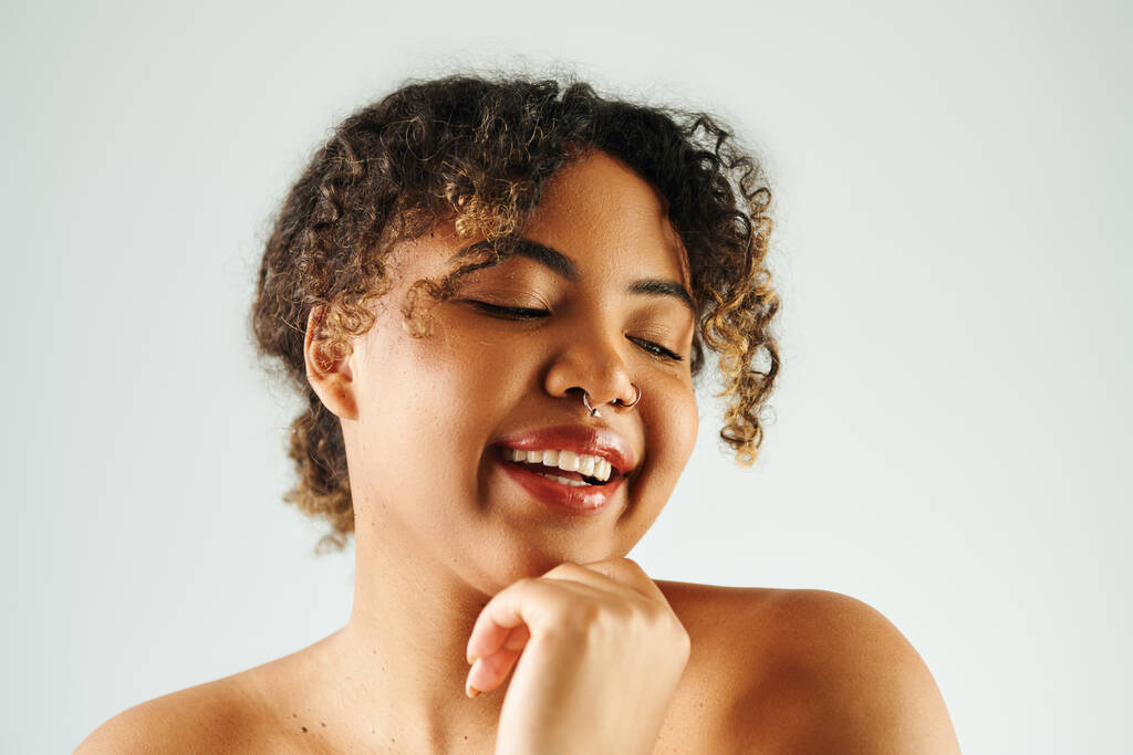 Femme afro-américaine avec les yeux fermés, main sous le menton, posant sereinement. - Photo, image