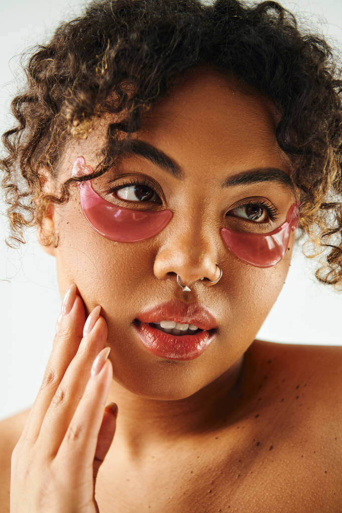Una hermosa mujer afroamericana con vibrantes manchas en los ojos rosados. - Foto, Imagen