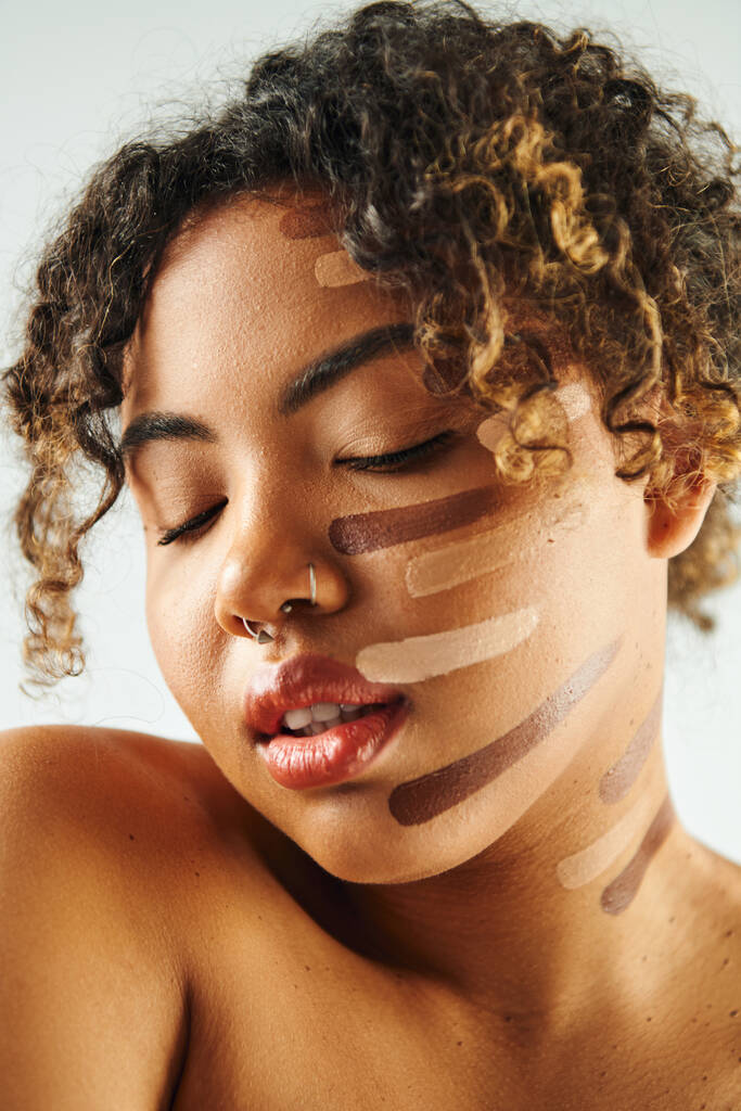 Mujer afroamericana bonita con base en la cara posa contra un telón de fondo vibrante. - Foto, imagen