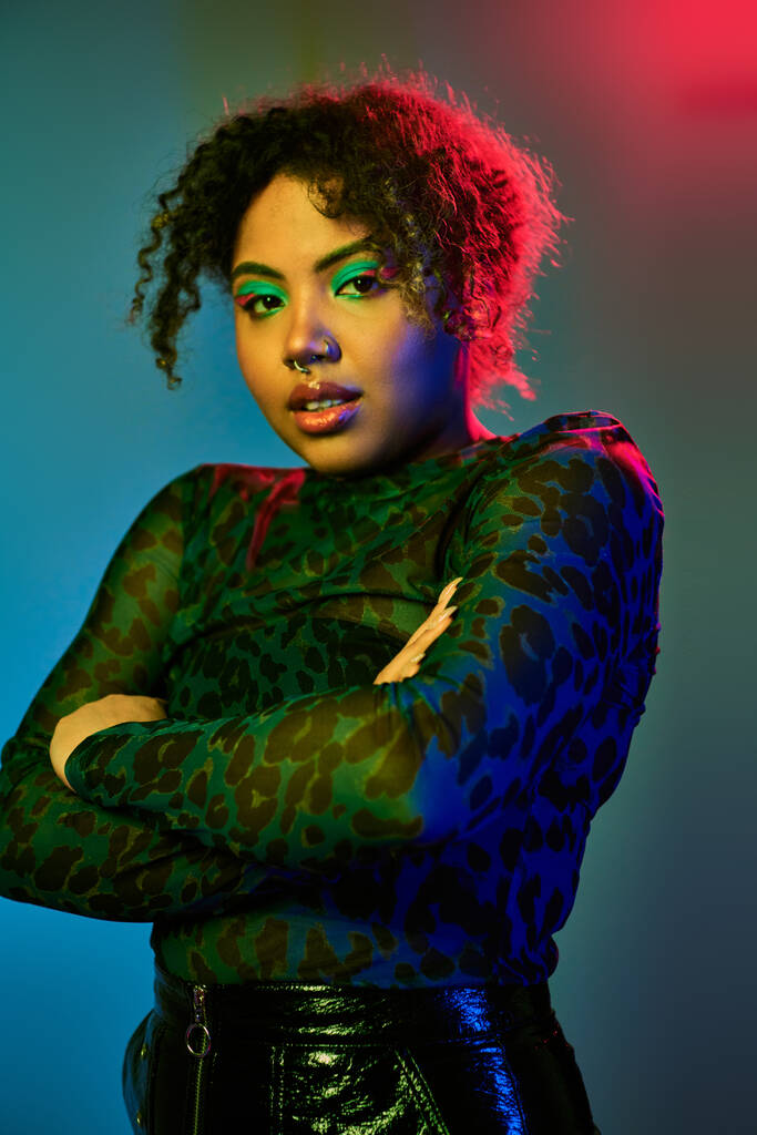 Αφροαμερικανή γυναίκα με σγουρά μαλλιά και πράσινα μάτια ποζάρει με χάρη. - Φωτογραφία, εικόνα