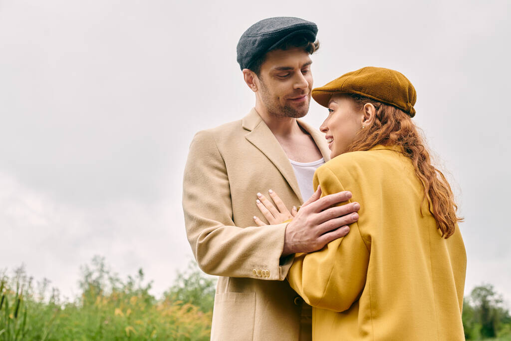 Ένας άντρας και μια γυναίκα στέκονται μαζί σε ένα καταπράσινο πάρκο, απολαμβάνοντας ένα ρομαντικό ραντεβού σε ένα γαλήνιο φυσικό περιβάλλον. - Φωτογραφία, εικόνα
