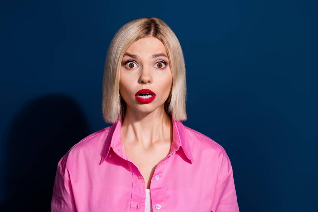 Φωτογραφία από άφωνος όμορφη γυναίκα με bob χτένισμα ντυμένο ροζ πουκάμισο έκπληκτος κοιτάζοντας ανοιχτό στόμα απομονώνονται σε σκούρο μπλε φόντο. - Φωτογραφία, εικόνα