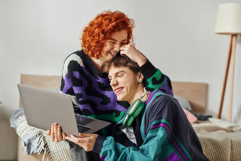buena pareja alegre en ropa vibrante divertirse mientras navega en Internet en el ordenador portátil - Foto, imagen