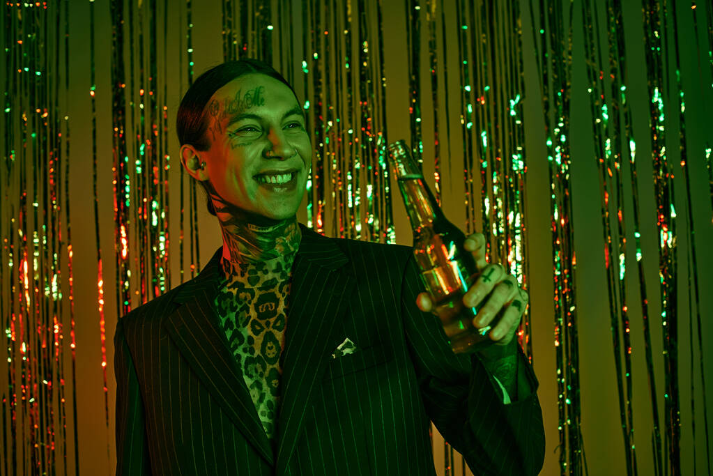 Σ 'ένα ρέιβ πάρτι, ένας άντρας με κοστούμι και γραβάτα κρατάει ένα μπουκάλι. - Φωτογραφία, εικόνα