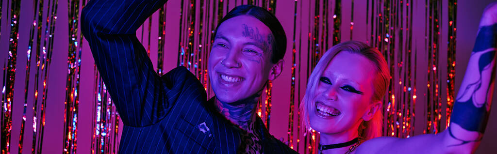 Un hombre y una mujer de pie lado a lado en una animada fiesta de rave o club nocturno de rave - Foto, Imagen