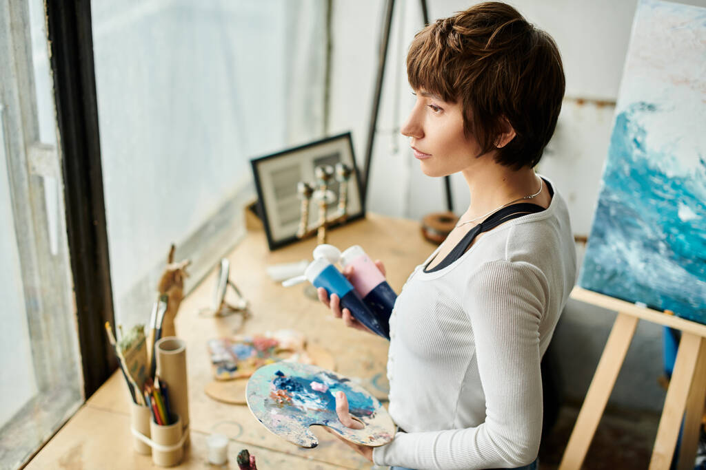 Frau fasziniert von Malerei auf Staffelei. - Foto, Bild