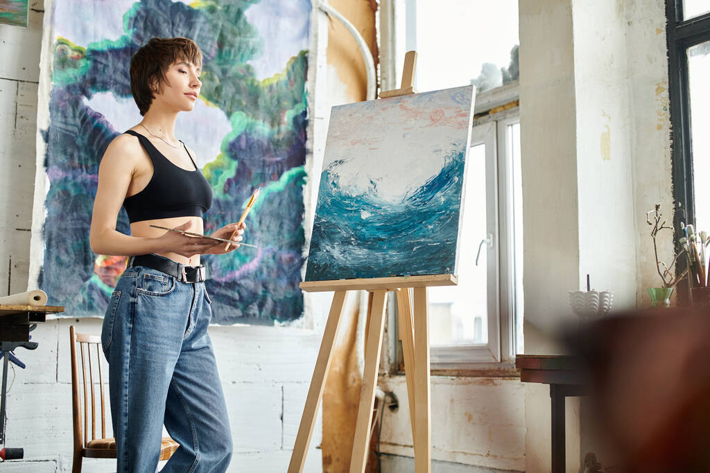 Een vrouw staat gefascineerd door een schilderij in een galerie. - Foto, afbeelding