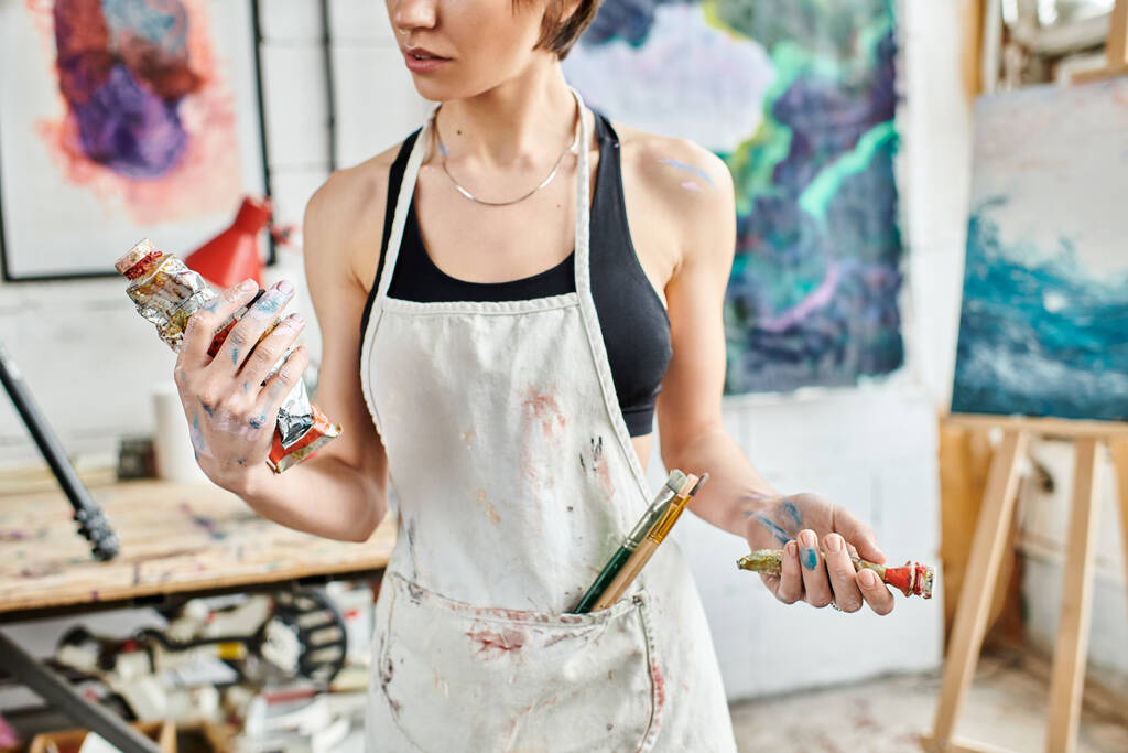 Женщина в художественной студии, с кистью в руке. - Фото, изображение