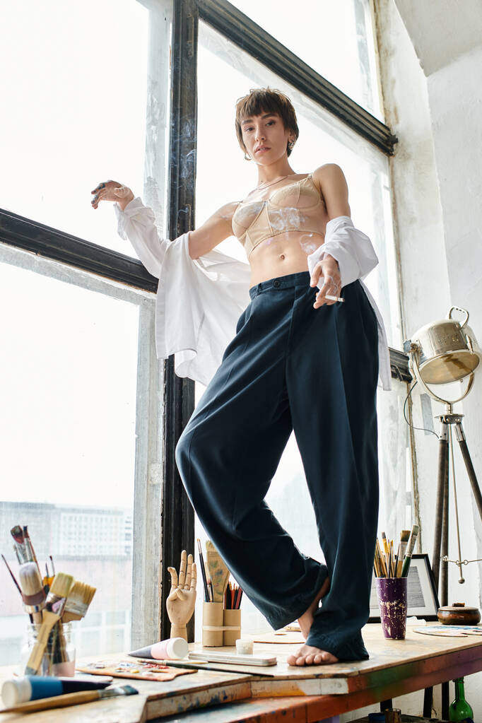 Μια γυναίκα στέκεται με αυτοπεποίθηση σε ένα περβάζι παραθύρου, σιλουέτα σε ένα παράθυρο. - Φωτογραφία, εικόνα