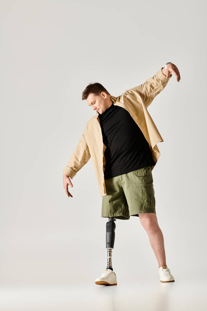 Um homem bonito com um gesso em uma perna e uma prótese na outra, marcando uma pose dinâmica. - Foto, Imagem