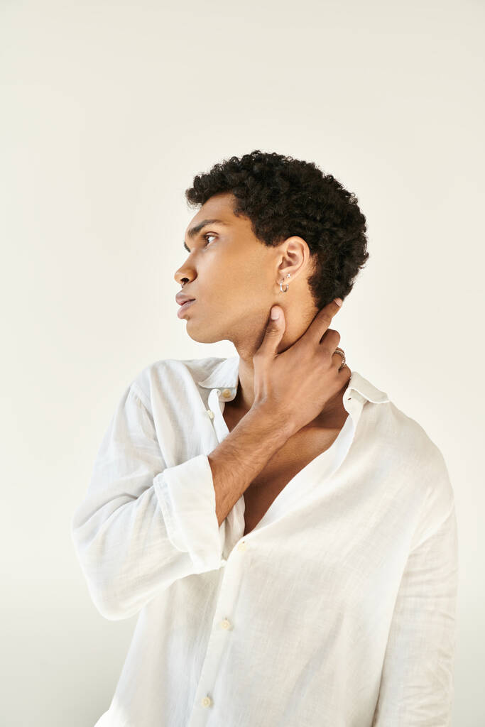 atractivo hombre afroamericano elegante en ropa de lino elegante mirando hacia otro lado en fondo beige - Foto, imagen