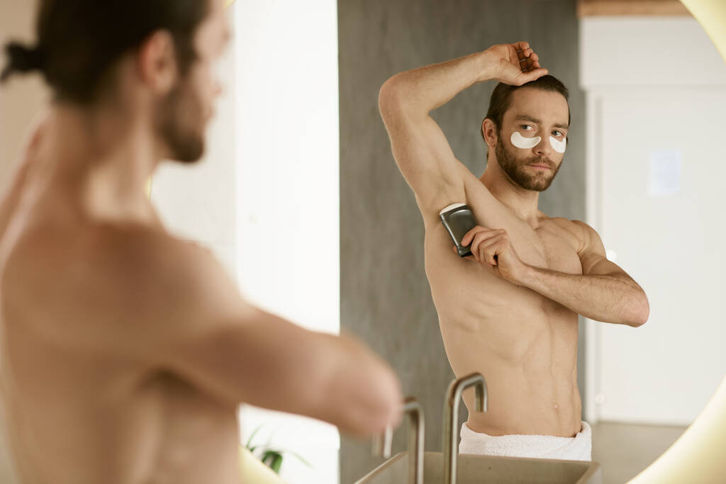 Shirtless man using deodorant at home. - Photo, Image