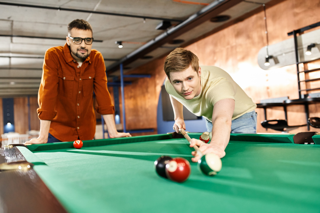 men strategize and compete in a game of pool, showcasing teamwork and friendly competition in a coworking space. - Photo, Image