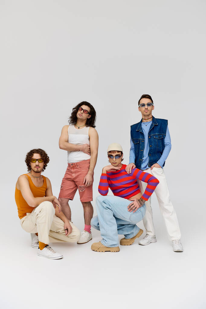 quatro atraente alegre gay amigos com elegante óculos de sol posando ativamente juntos, orgulho mês - Foto, Imagem