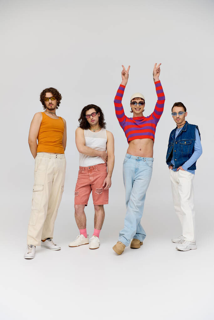 vier elegante fröhliche schwule Freunde mit stylischer Sonnenbrille posieren aktiv zusammen, stolzer Monat - Foto, Bild