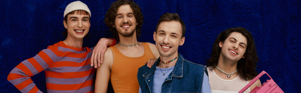 vier lustige gut aussehende stilvolle schwule Männer in lässigen Outfits posieren mit Tonbandgerät, Stolz Monat, Banner - Foto, Bild