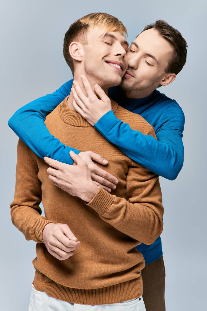 Двое мужчин в повседневной одежде крепко обнимают друг друга. - Фото, изображение
