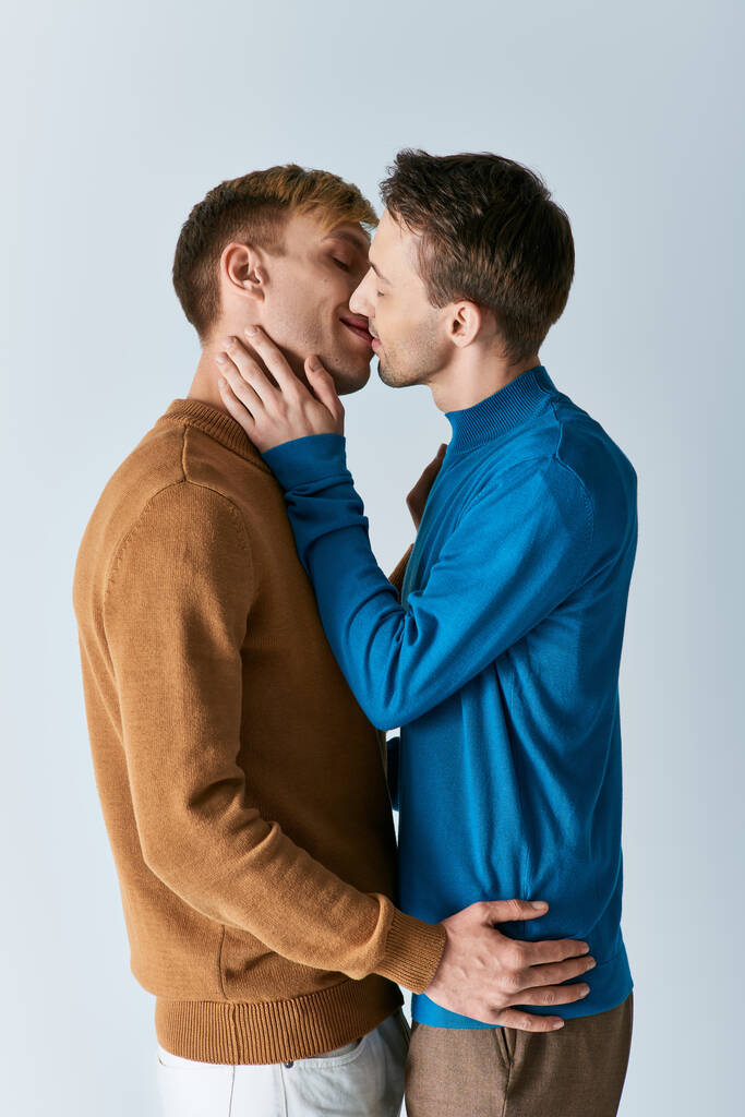 Dos hombres, una pareja gay amorosa, se paran uno al lado del otro sobre un fondo blanco. - Foto, Imagen
