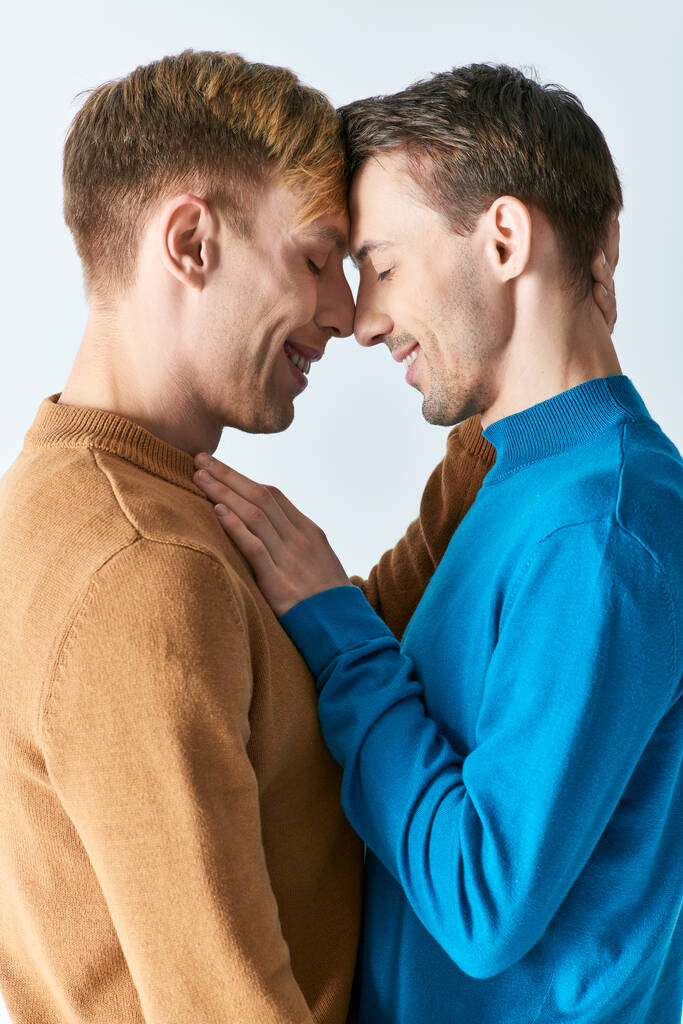 amante gay pareja en casual traje pose en gris telón de fondo. - Foto, imagen