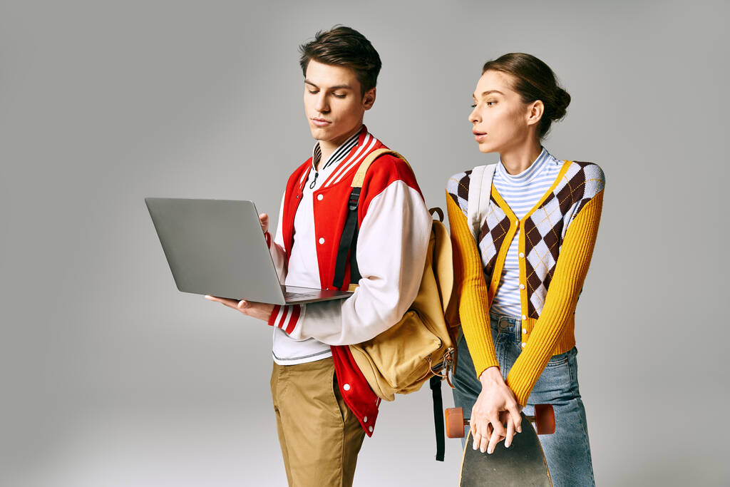 Jovens estudantes do sexo masculino e feminino em pé junto com um laptop em uma sala de aula da faculdade. - Foto, Imagem