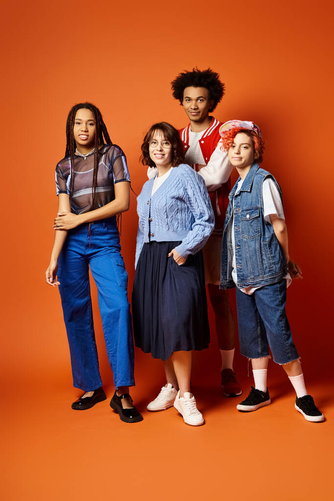 A group of young multicultural friends, including a nonbinary person, standing together in stylish attire in a studio setting. - Photo, Image