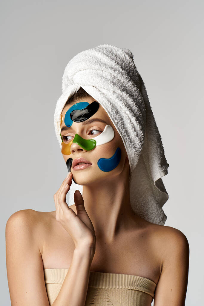 Όμορφη γυναίκα με πετσέτα τυλιγμένη γύρω από το κεφάλι και τα μάτια της μπαλώματα. - Φωτογραφία, εικόνα