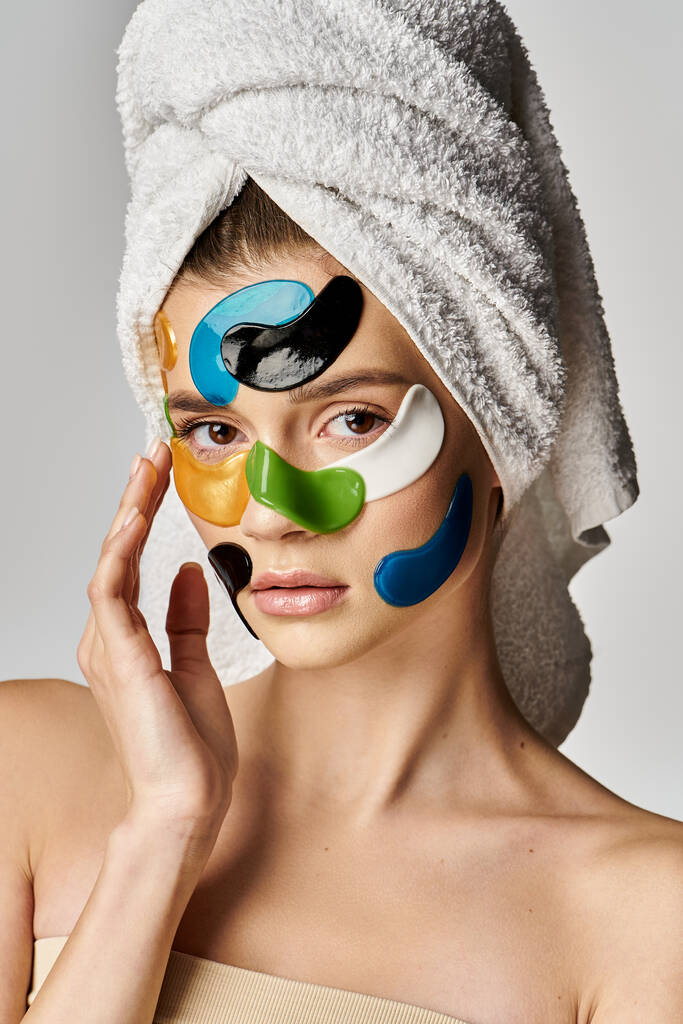 Μοντέρνα γυναίκα με μια πετσέτα τυλιγμένη γύρω από το κεφάλι και τα μάτια της μπαλώματα. - Φωτογραφία, εικόνα