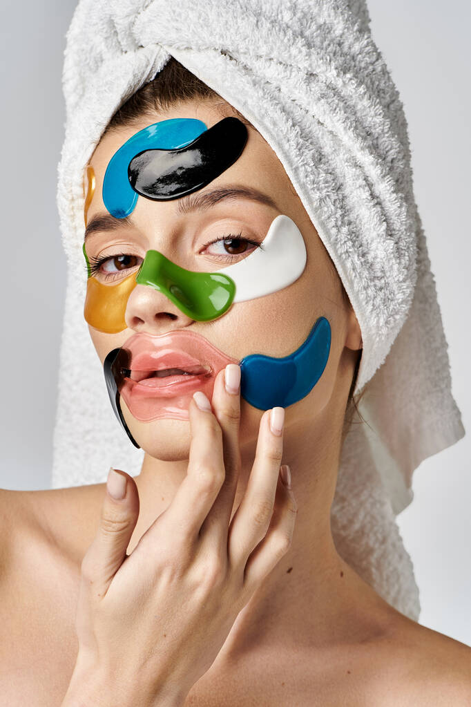Ohromující mladá žena s ručníkem omotaným kolem hlavy s páskou přes oko na tváři, zvýrazňující její přirozenou krásu. - Fotografie, Obrázek