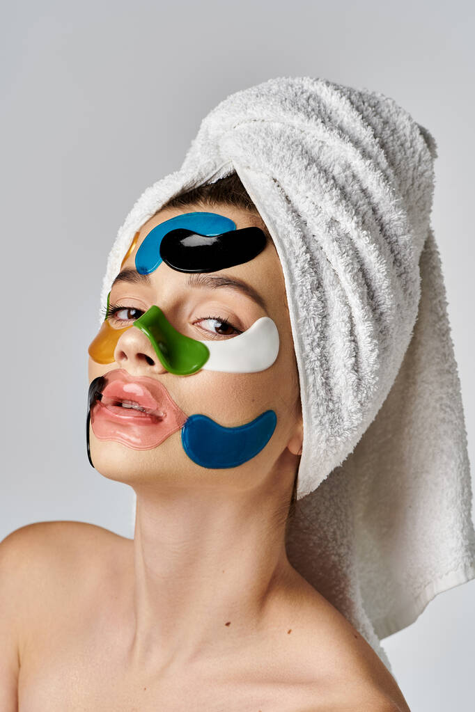 Молода жінка з рушником на голові, що демонструє художні плями очей. - Фото, зображення