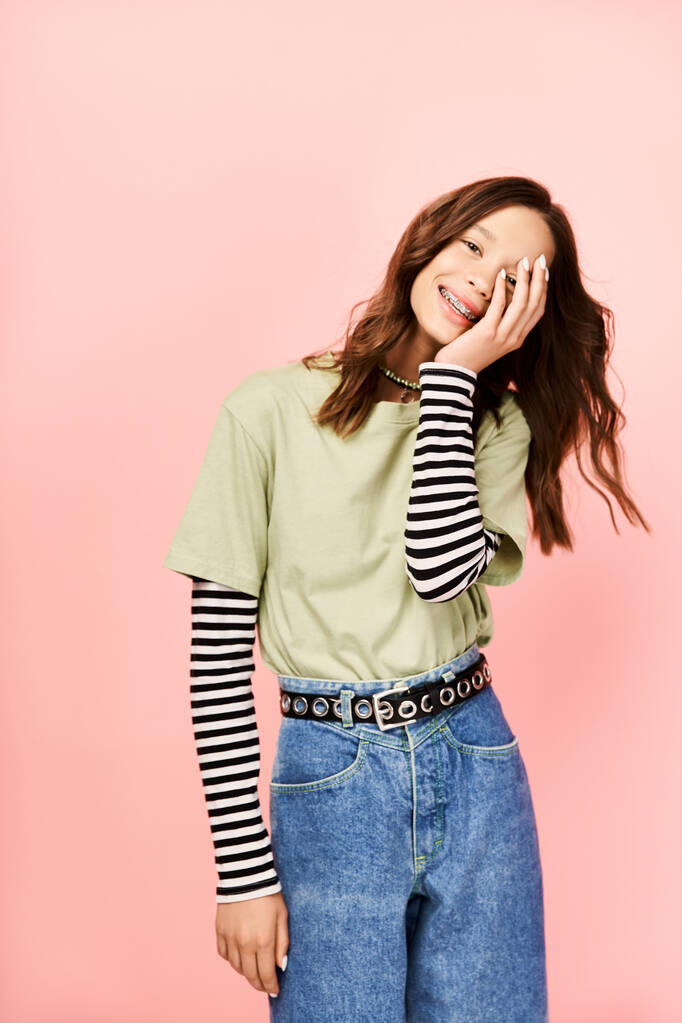 Ein stilvolles Teenager-Mädchen in grünem Hemd und Jeans posiert energisch. - Foto, Bild