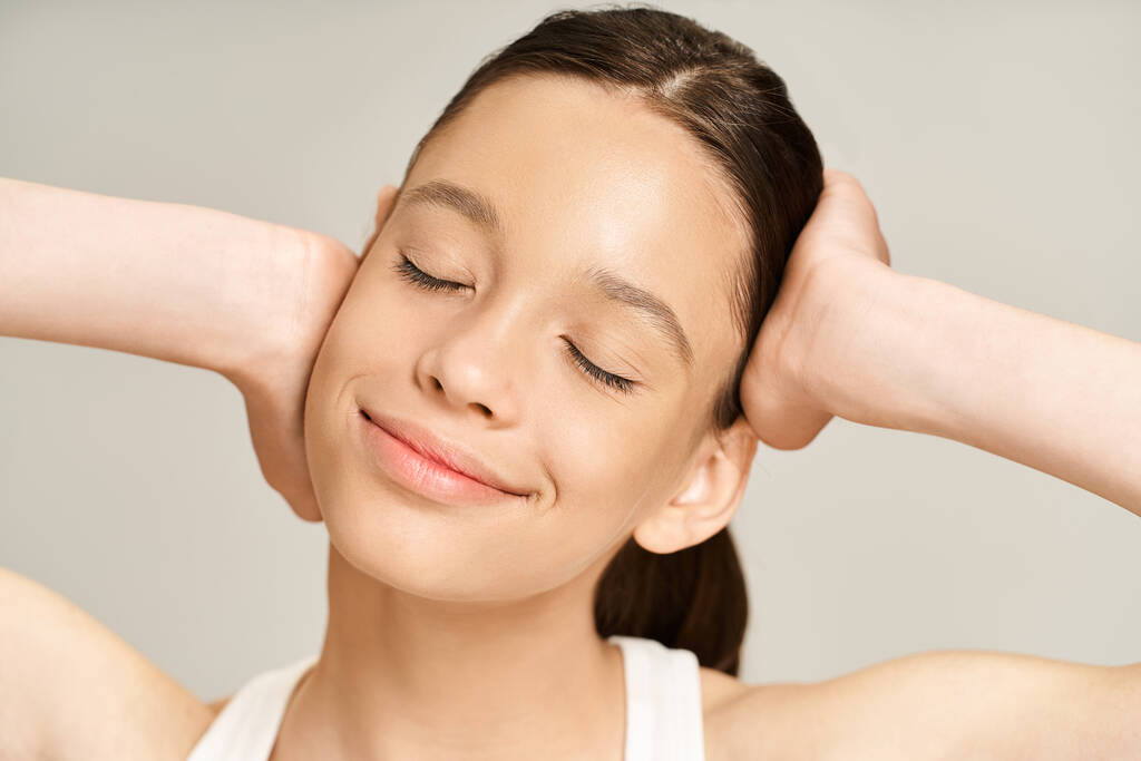 Une adolescente élégante et vibrante avec les mains sur la tête dans une pose de détresse et de contemplation. - Photo, image