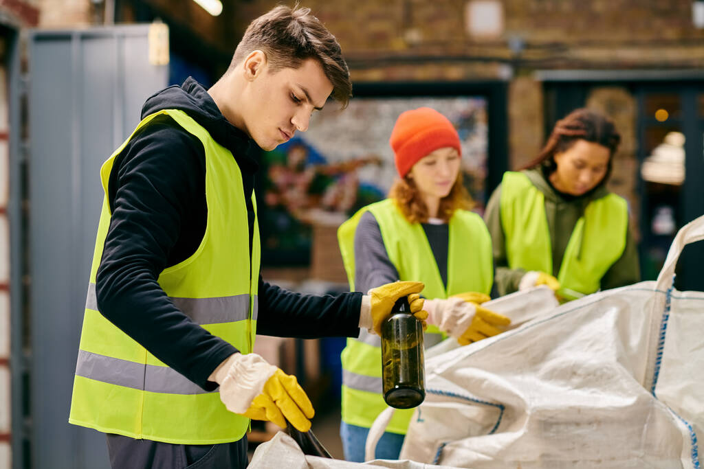 A group of eco-conscious young volunteers in yellow vests and gloves sorting trash together. - Foto, immagini