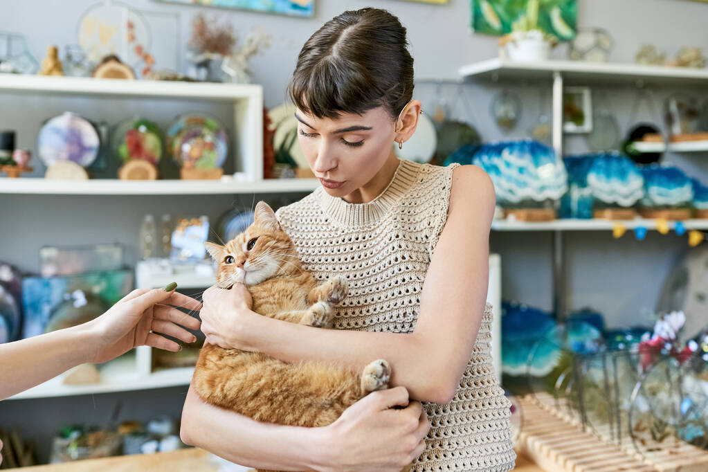 Eine Frau hält eine Katze zärtlich auf dem Arm. - Foto, Bild